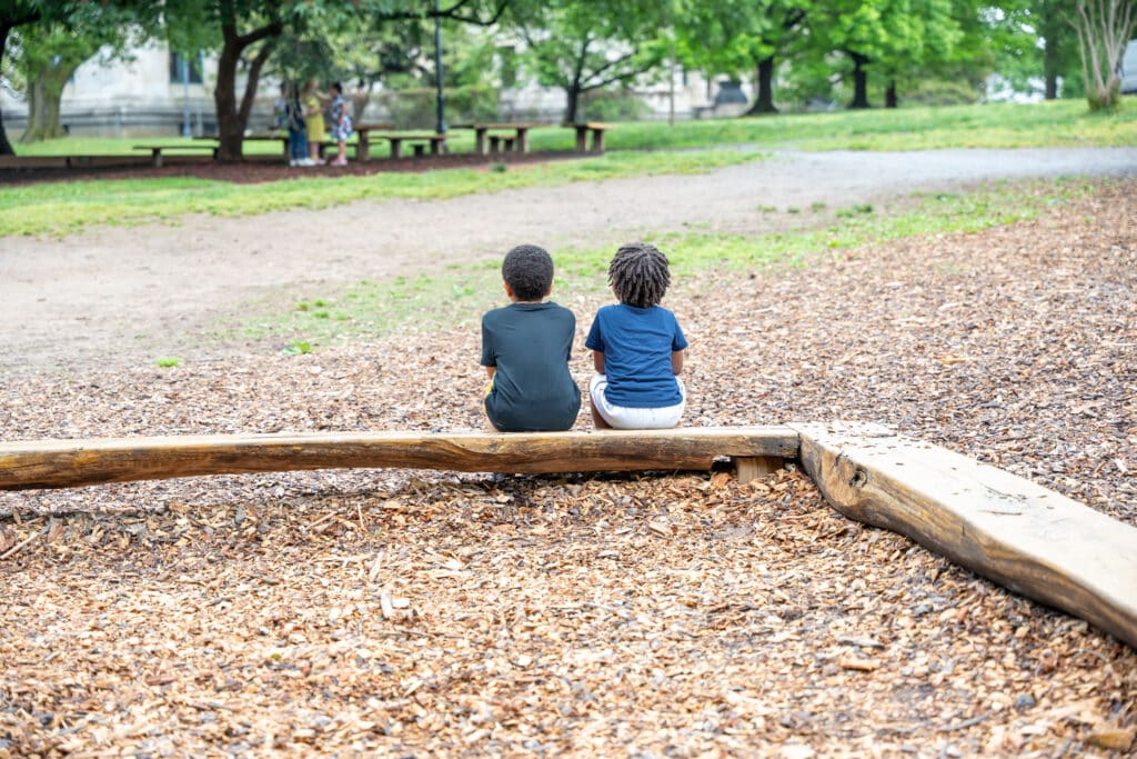 two children sit on a bench