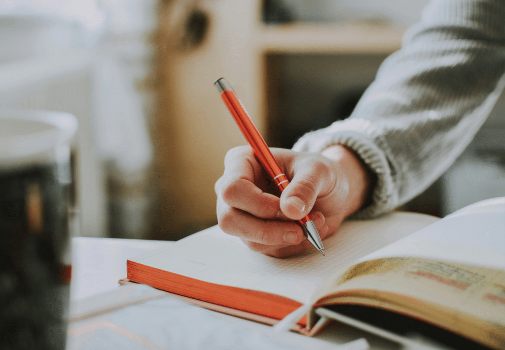 person writing in notebook