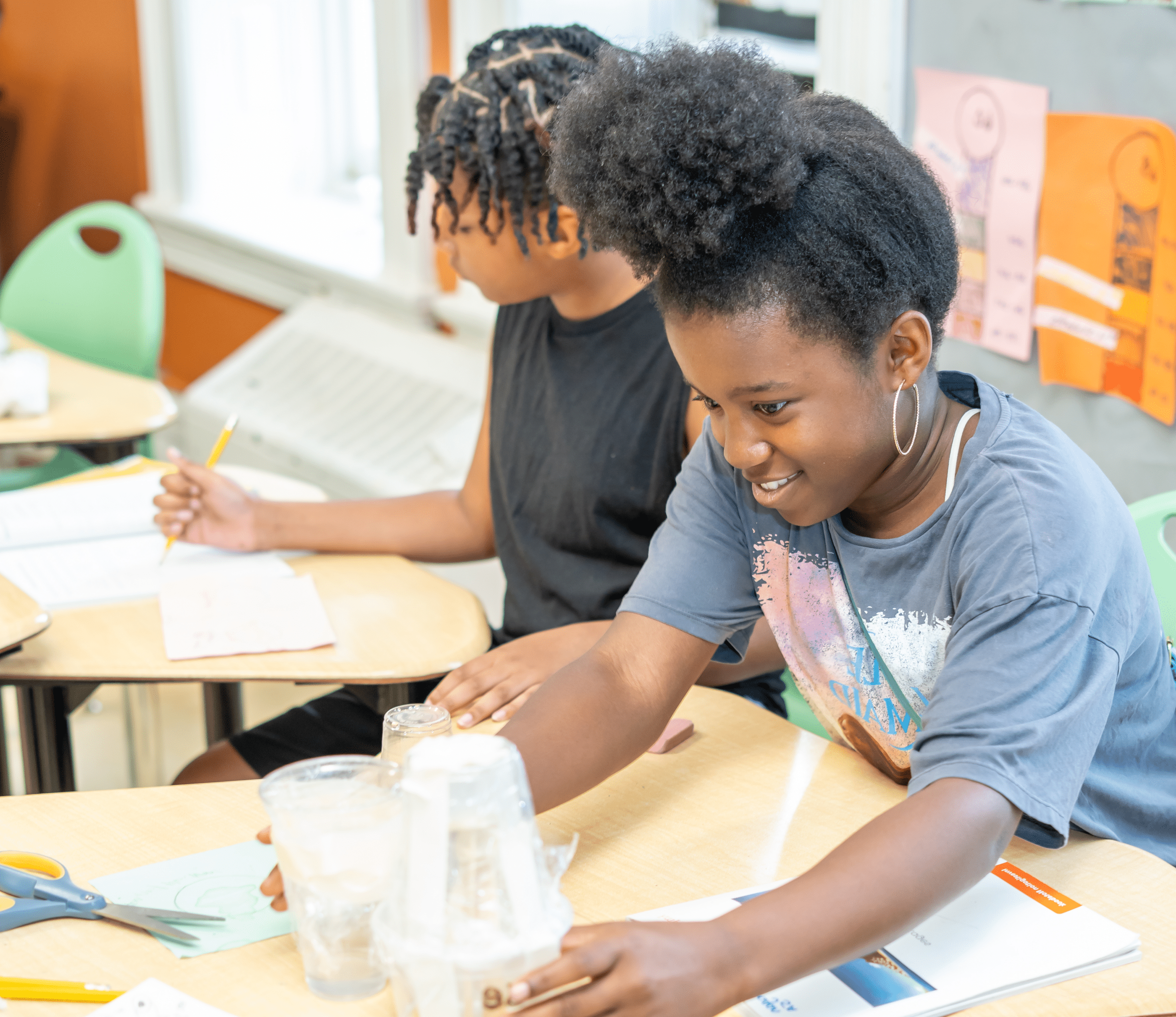 girl smiles as she works on project