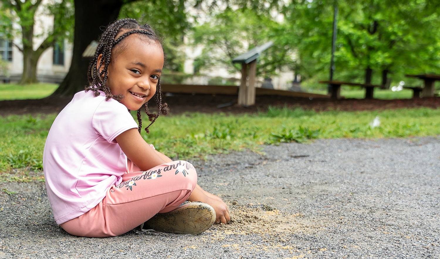 young girl sitting outside smiling