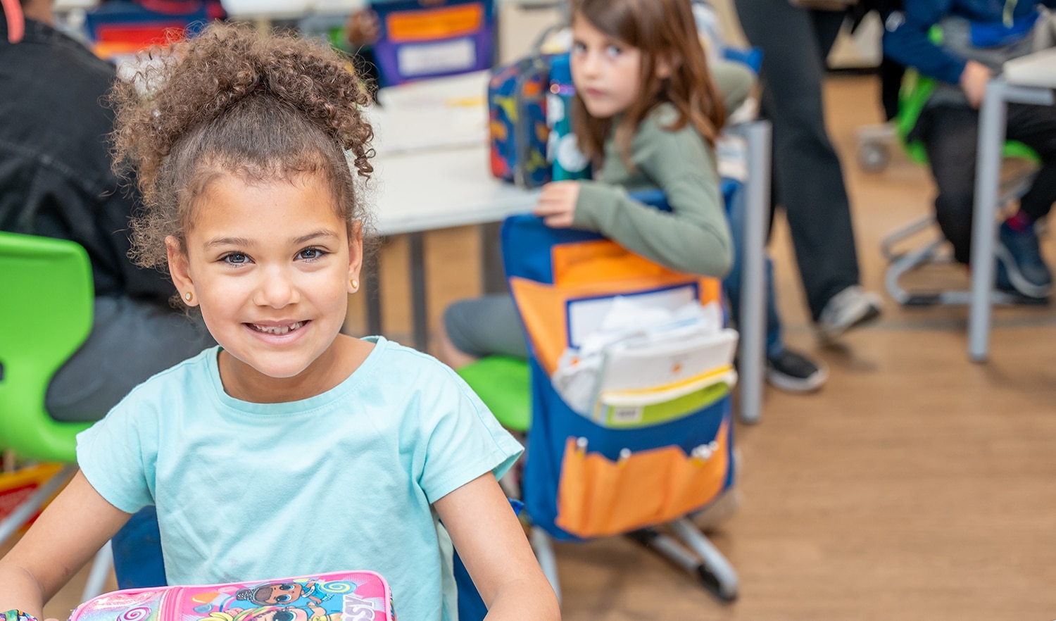 young girl with lunchbox smiles